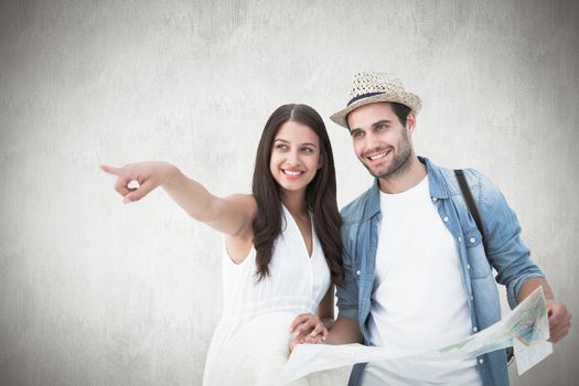 Happy hipster couple looking at map against white background