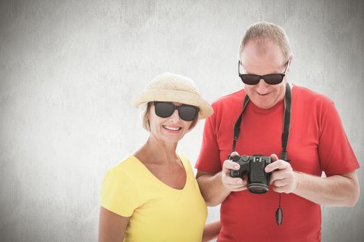 Happy mature couple wearing sunglasses against white background