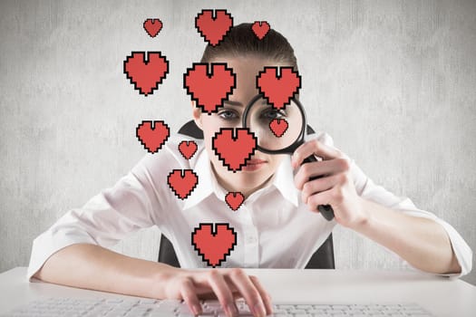 Businesswoman typing and looking through magnifying glass against white and grey background