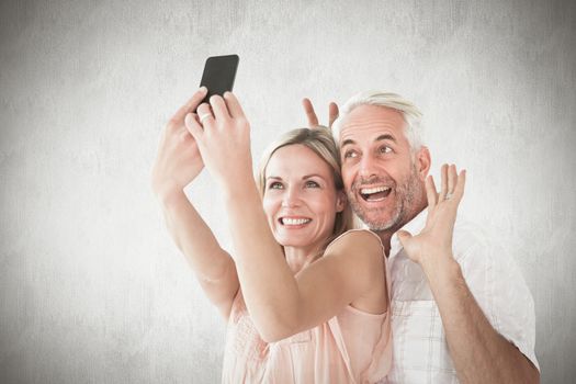 Happy couple posing for a selfie against white background