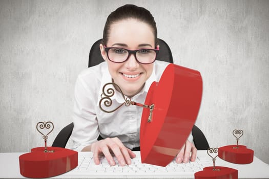 Businesswoman typing on a keyboard against white and grey background