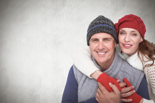 Happy couple in warm clothing against white background