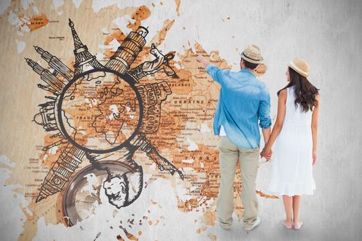 Happy hipster couple holding hands and looking against world map with compass showing southern asia