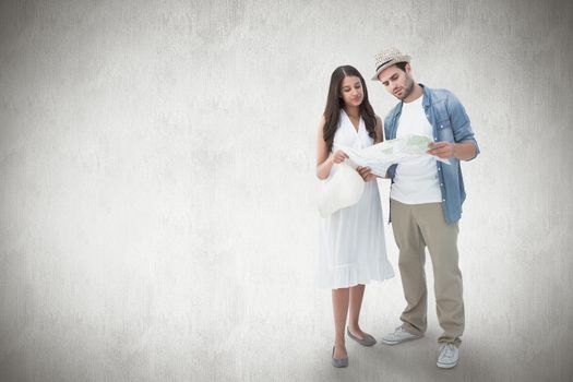 Lost hipster couple looking at map against white background