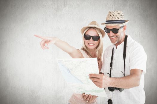 Happy tourist couple using map and pointing against white background