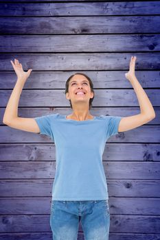 Pretty brunette gesturing against wooden planks background