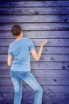 Pretty brunette playing air guitar against wooden planks background