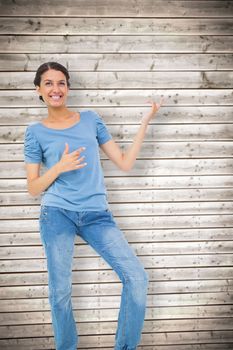 Pretty brunette playing air guitar against wooden planks background