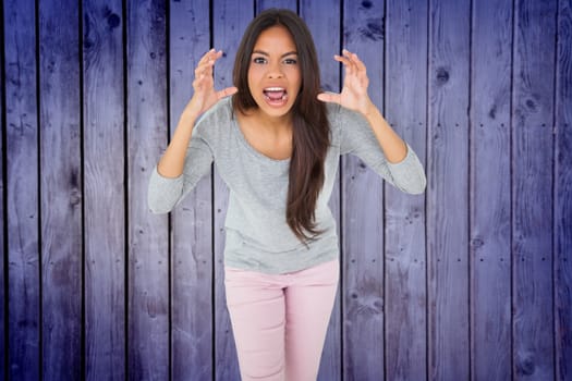 Angry brunette shouting against wooden planks background