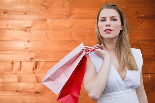 Blonde with shopping bags against overhead of wooden planks