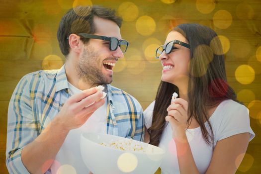 Attractive young couple watching a 3d movie against close up of christmas lights