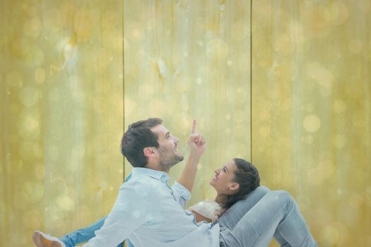 Attractive young couple lying down against blue abstract light spot design