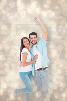 Happy casual couple cheering at camera against light glowing dots design pattern