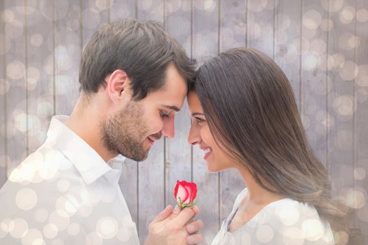 Handsome man offering his girlfriend a rose against light glowing dots design pattern