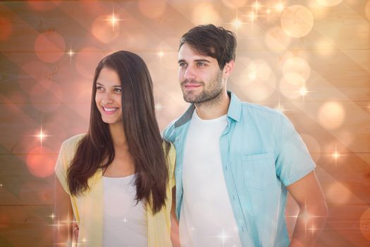 Happy casual couple smiling together against light design shimmering on red