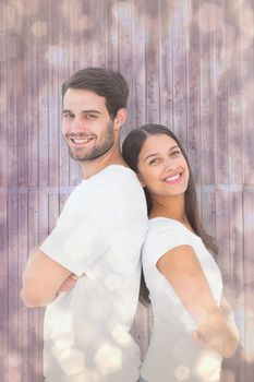 Happy couple smiling at camera against light glowing dots design pattern