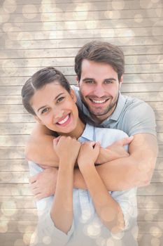 Cute couple smiling at camera against light glowing dots design pattern