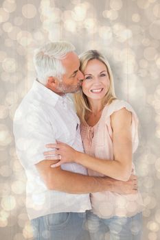 Affectionate man kissing his wife on the cheek against light glowing dots design pattern