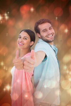 Happy couple showing thumbs up against light design shimmering on red