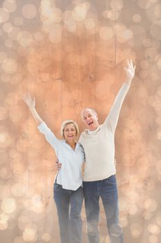 Happy mature couple cheering at camera against light glowing dots design pattern