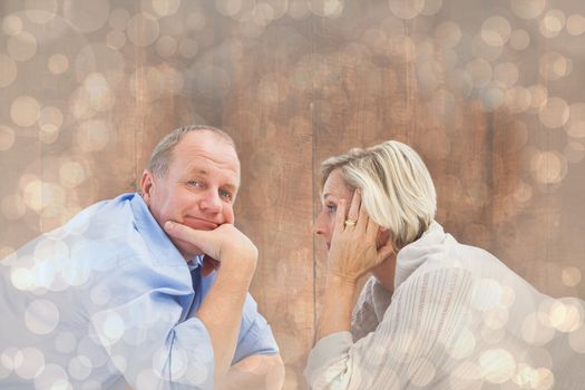 Mature couple lying and smiling against light glowing dots design pattern