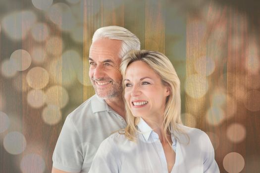 Happy couple smiling and embracing against light circles on bright background