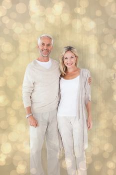 Happy couple smiling at camera together against light glowing dots design pattern