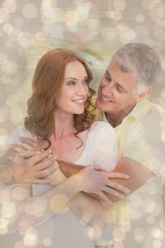 Casual couple hugging and smiling against light glowing dots design pattern