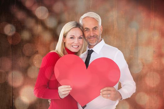 Handsome man getting a heart card form wife against light circles on black background