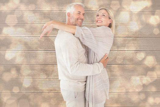 Happy couple standing and hugging against light glowing dots design pattern