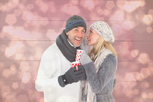 Happy couple in winter fashion holding mugs against light glowing dots design pattern