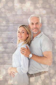 Happy couple smiling at camera against light glowing dots design pattern
