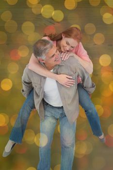 Casual couple having fun together against close up of christmas lights