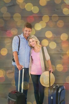 Attractive young couple ready to go on vacation against close up of christmas lights