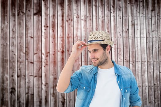 Handsome hipster wearing a trilby against wooden planks