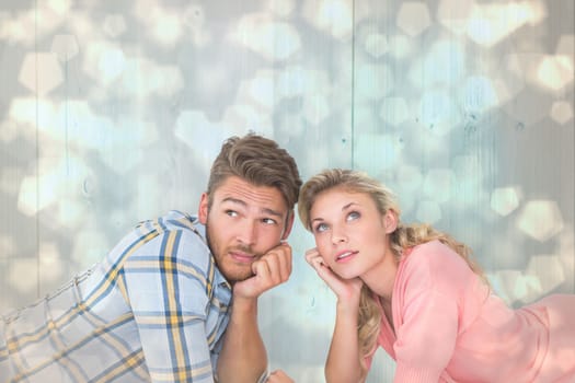 Attractive young couple lying and thinking against light glowing dots design pattern