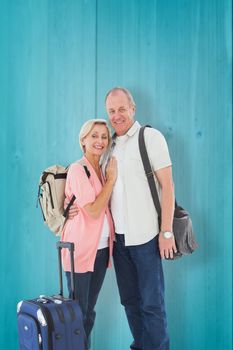 Smiling older couple going on their holidays against wooden planks background