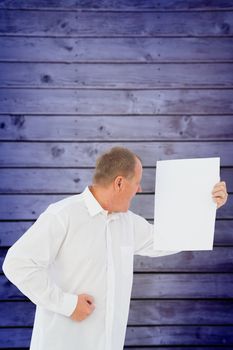 Angry man shouting at piece of paper against wooden planks background