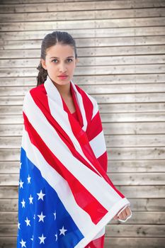 Pretty brunette wearing the american flag against wooden planks background
