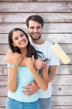 Happy young couple painting together against wooden planks