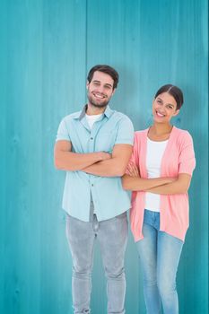 Happy couple with arms crossed against wooden planks background