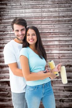 Happy young couple painting together against wooden planks