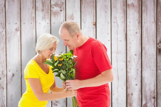 Mature man offering his partner flowers against wooden planks