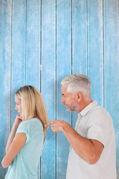 Angry man pointing at his wife against wooden planks