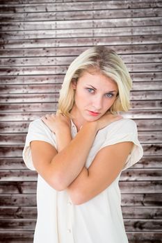 Sad pretty blonde looking at camera against wooden planks