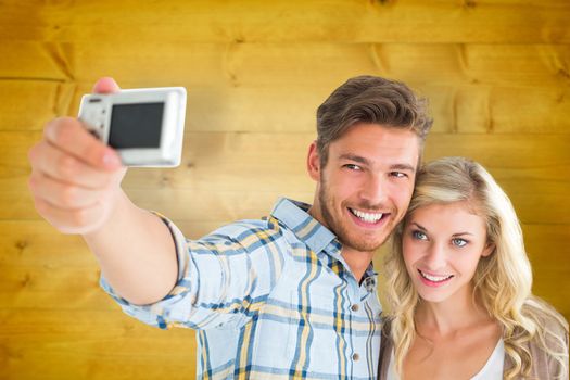 Attractive couple taking a selfie together against wooden planks background