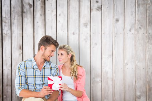 Couple with gift against wooden planks