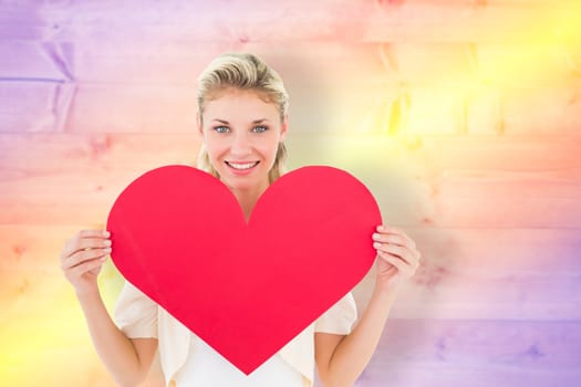 Attractive young blonde showing red heart against yellow and purple planks