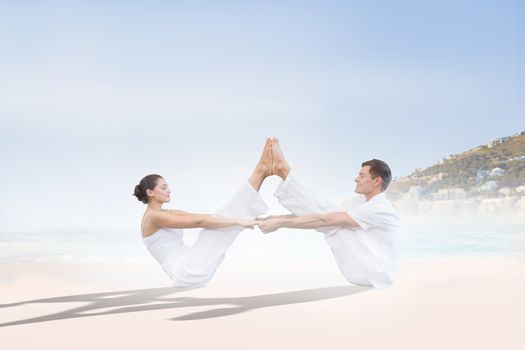 Peaceful couple sitting in boat position together against beautiful beach and blue sky