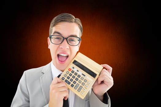 Geeky smiling businessman showing calculator against white and grey background